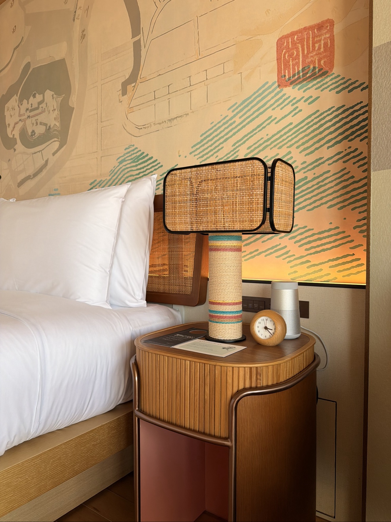 Nightstand with rattan lamp, Bose speaker and clock