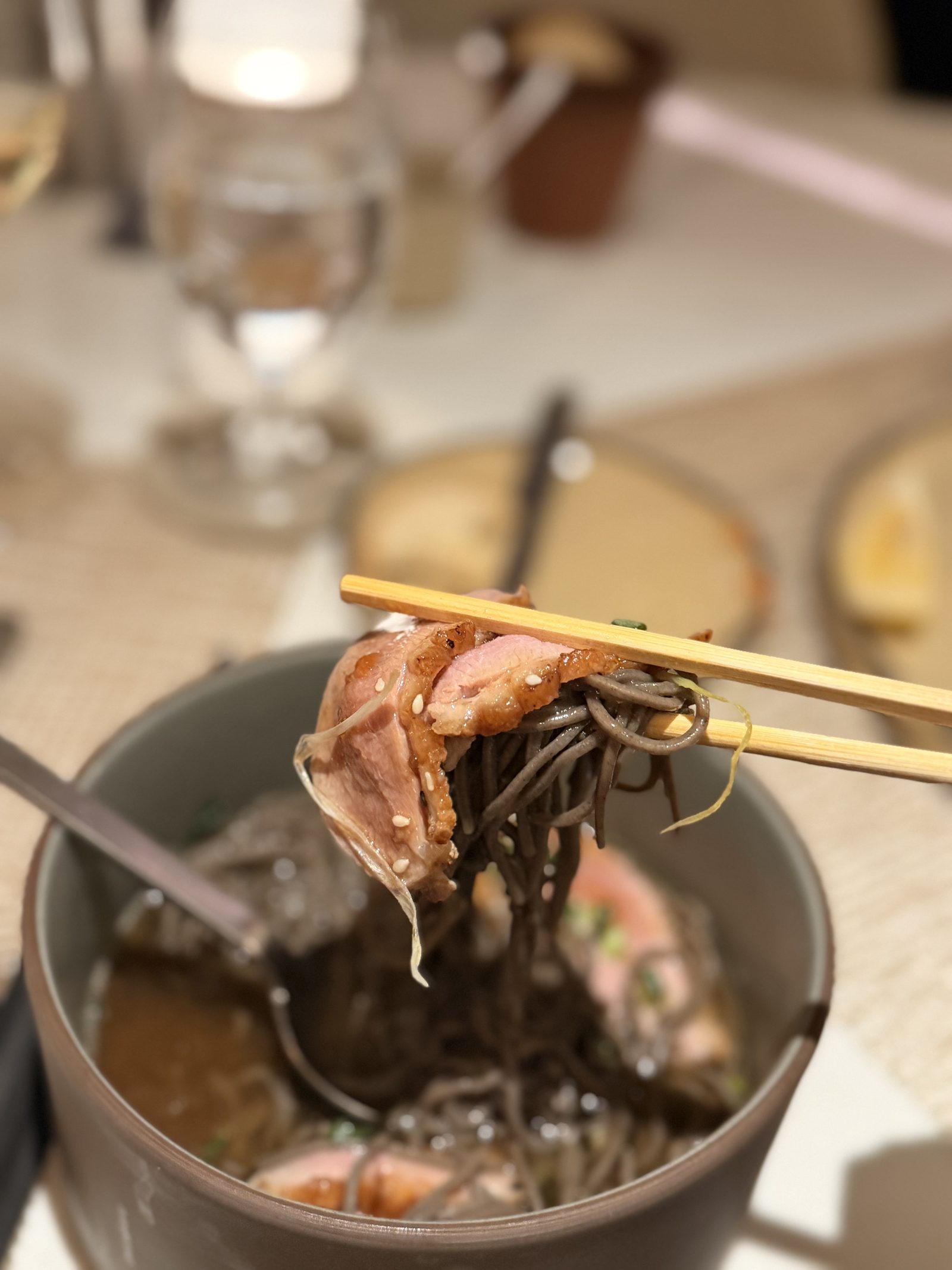 鴨とそばをひと箸。鴨の皮は金色に焼けています。