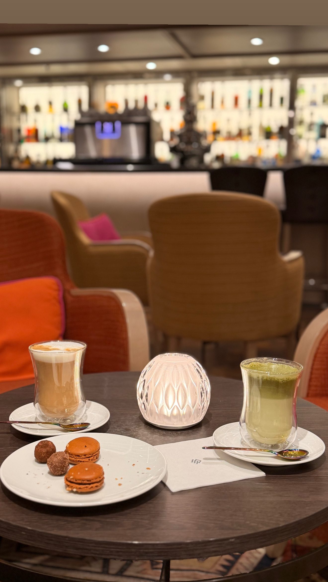 コーヒーとプチフール。背景のバーの明かりはやわらかく。