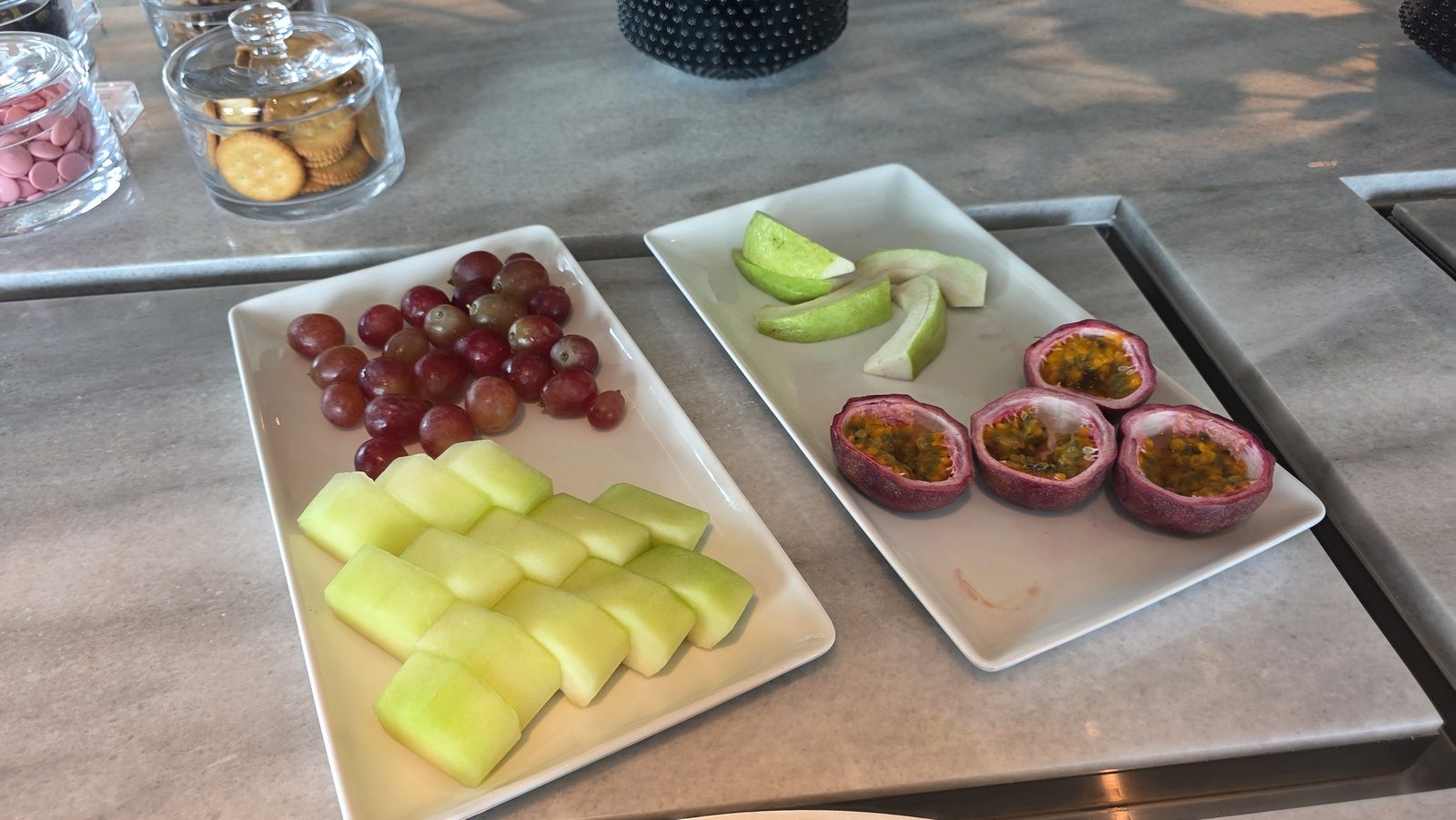 Cut fruit on a long platter: grapes, melon, guava and passion fruit