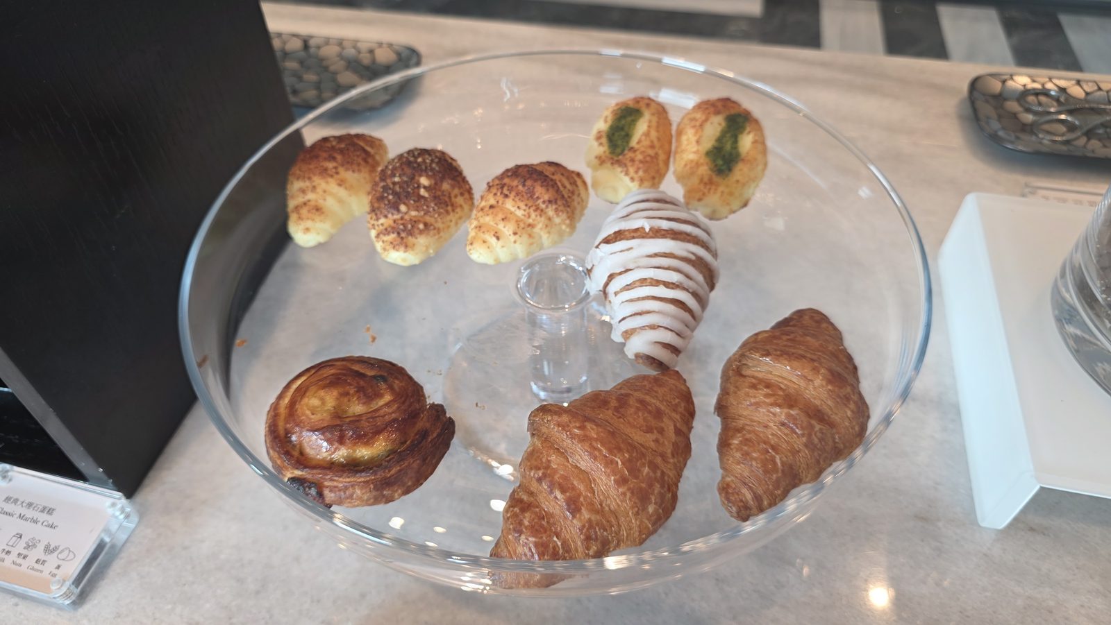 Croissants and puff pastries on a glass stand