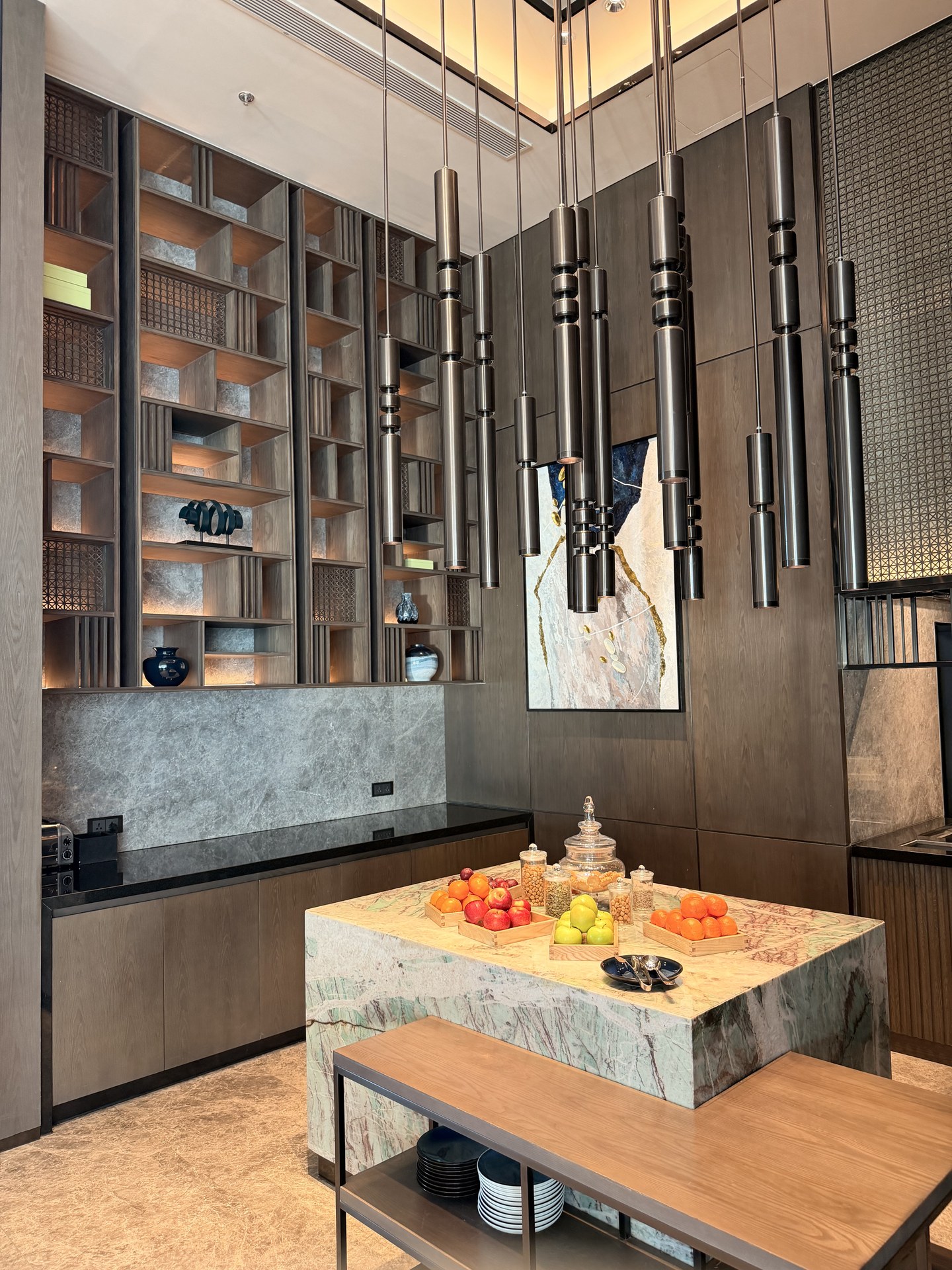 The bar island: a fruit counter, shelving wall and pendant lights.