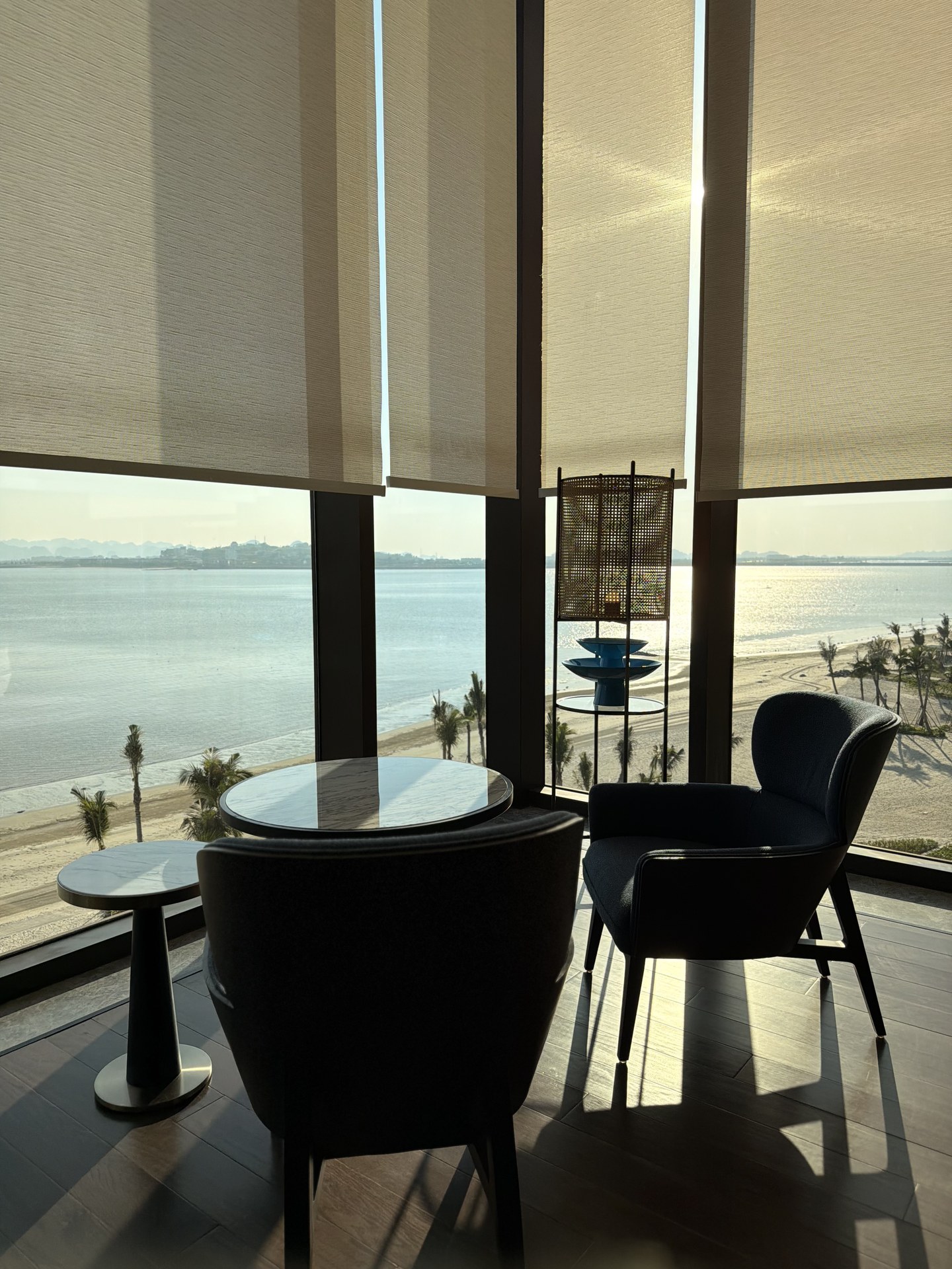 A round table by the glass, the bay right outside.