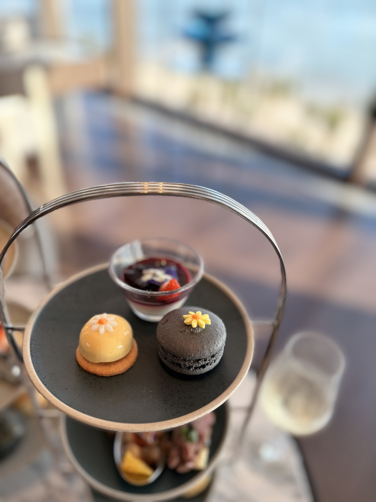 Top tier close-up: a macaron and petit cakes.